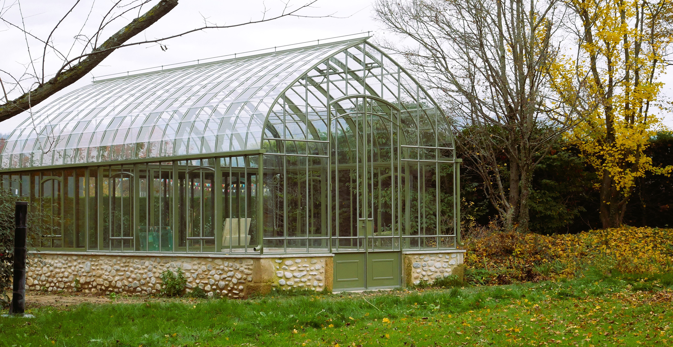 Serre 4 faces sur muret avec grande porte pour l'hivernage des plantes